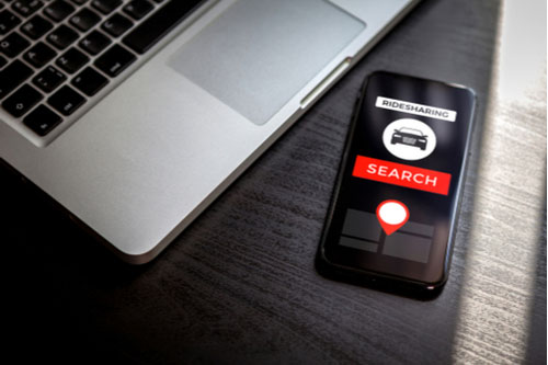 Phone with ridesharing app, concept of Uber accident injuries in Naples