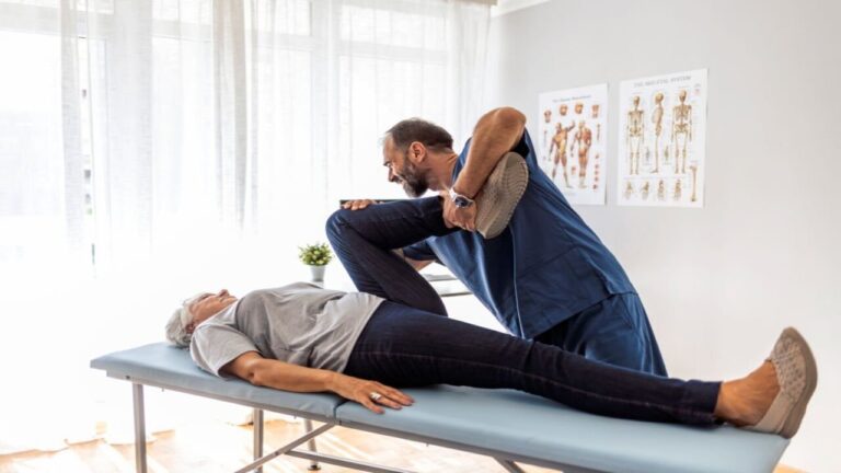 Male Doctor Chiropractor Fixing Womans Leg with Hands Movements