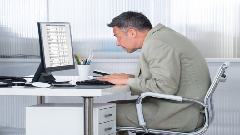 Man Sitting with Poor Posture Using a Computer in Office