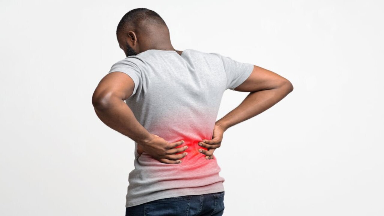 A Guy Holding Both Hands on His Lower Back with Pain